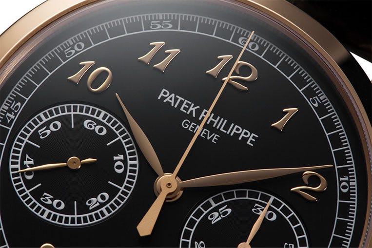 Breguet numerals in rose gold complement the black dial and white print